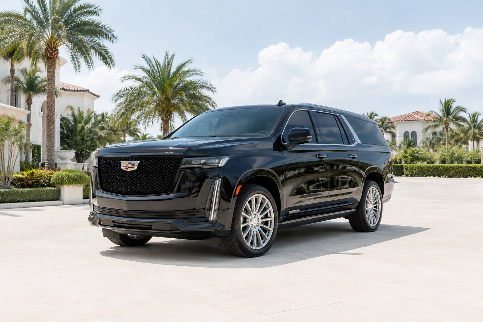 Black luxury SUV on a paved forecourt beside palms in South Florida