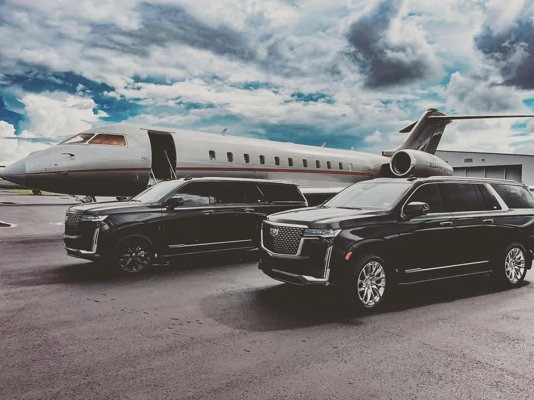 A black Aura Palm SUV beside a private jet on a South Florida FBO ramp