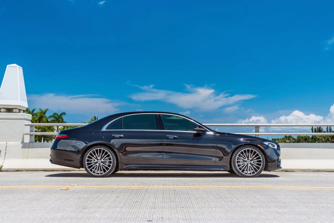 A black Aura Palm sedan on a South Florida causeway bridge under a bright blue sky